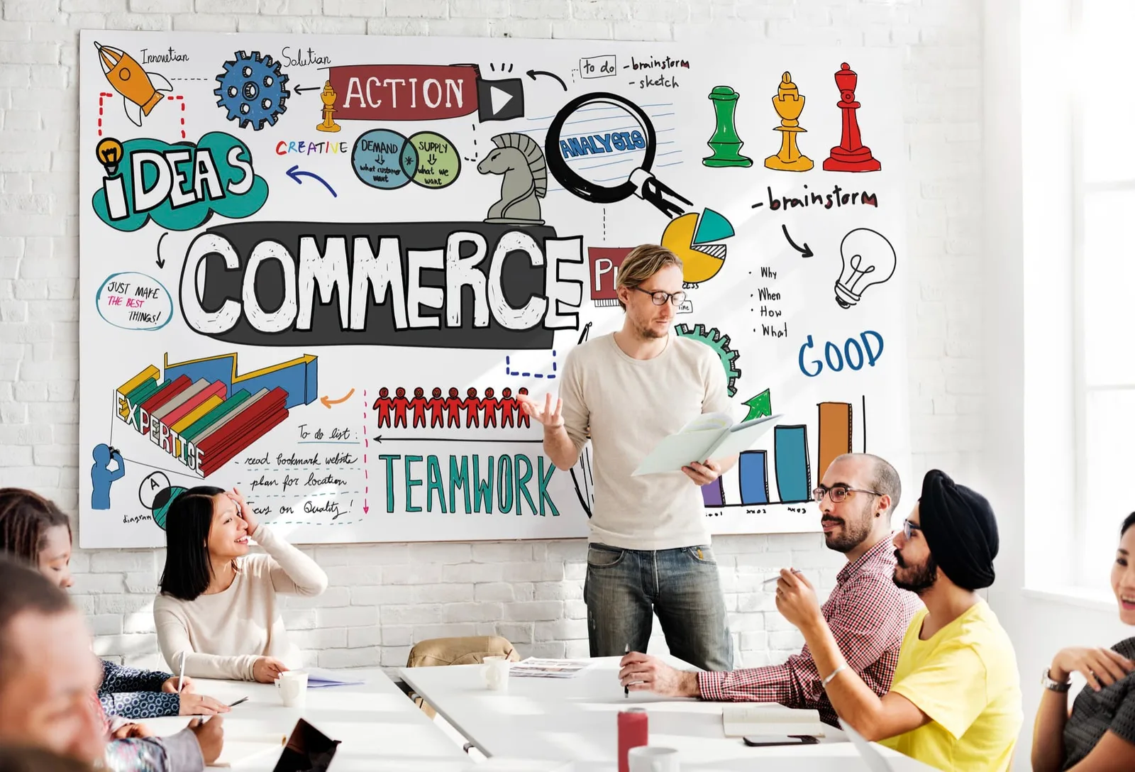 Entrepreneur individuel présentant un schéma de business model sur un tableau blanc lors d’un échange de travail