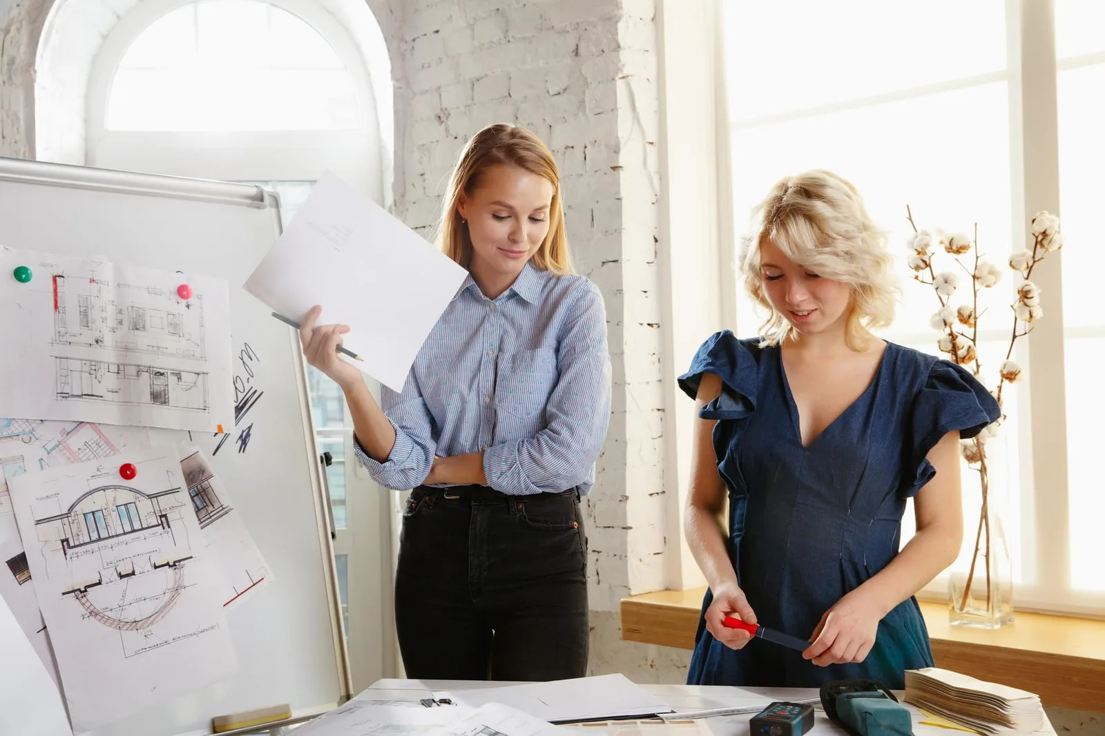 Photo d’un entrepreneur comparant des documents juridiques et un tableau de choix de statut