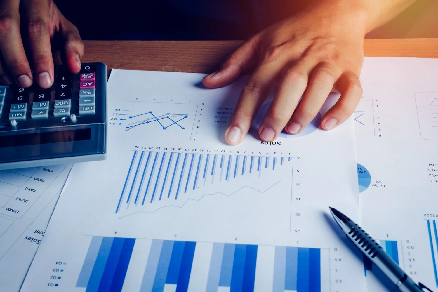 Un chef d’entreprise consultant un tableau de suivi des risques avec ordinateur portable et documents financiers sur un bureau