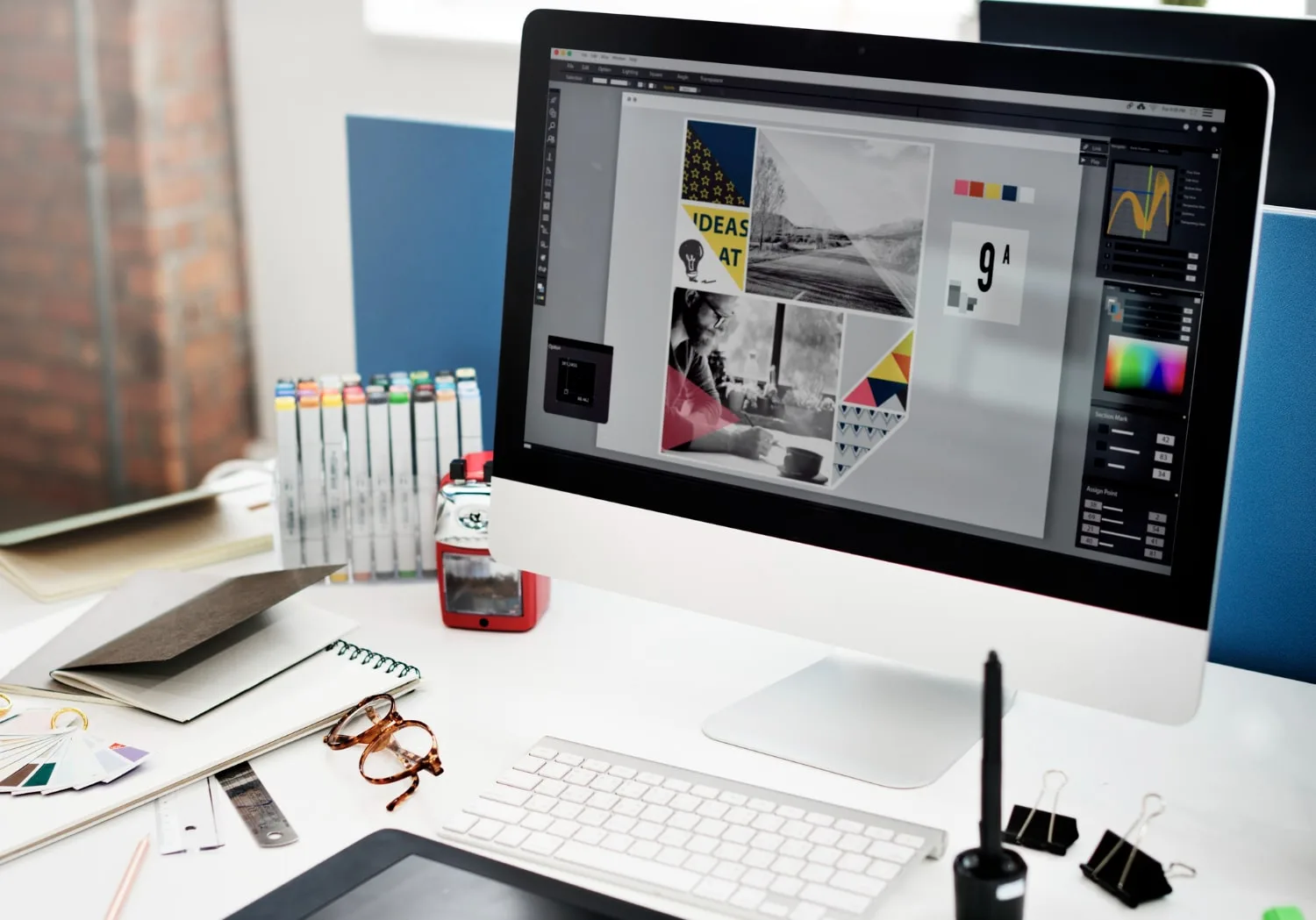 Freelance ou dirigeant de petite entreprise travaillant sur une identité visuelle avec ordinateur, carnet, logo et smartphone sur un bureau