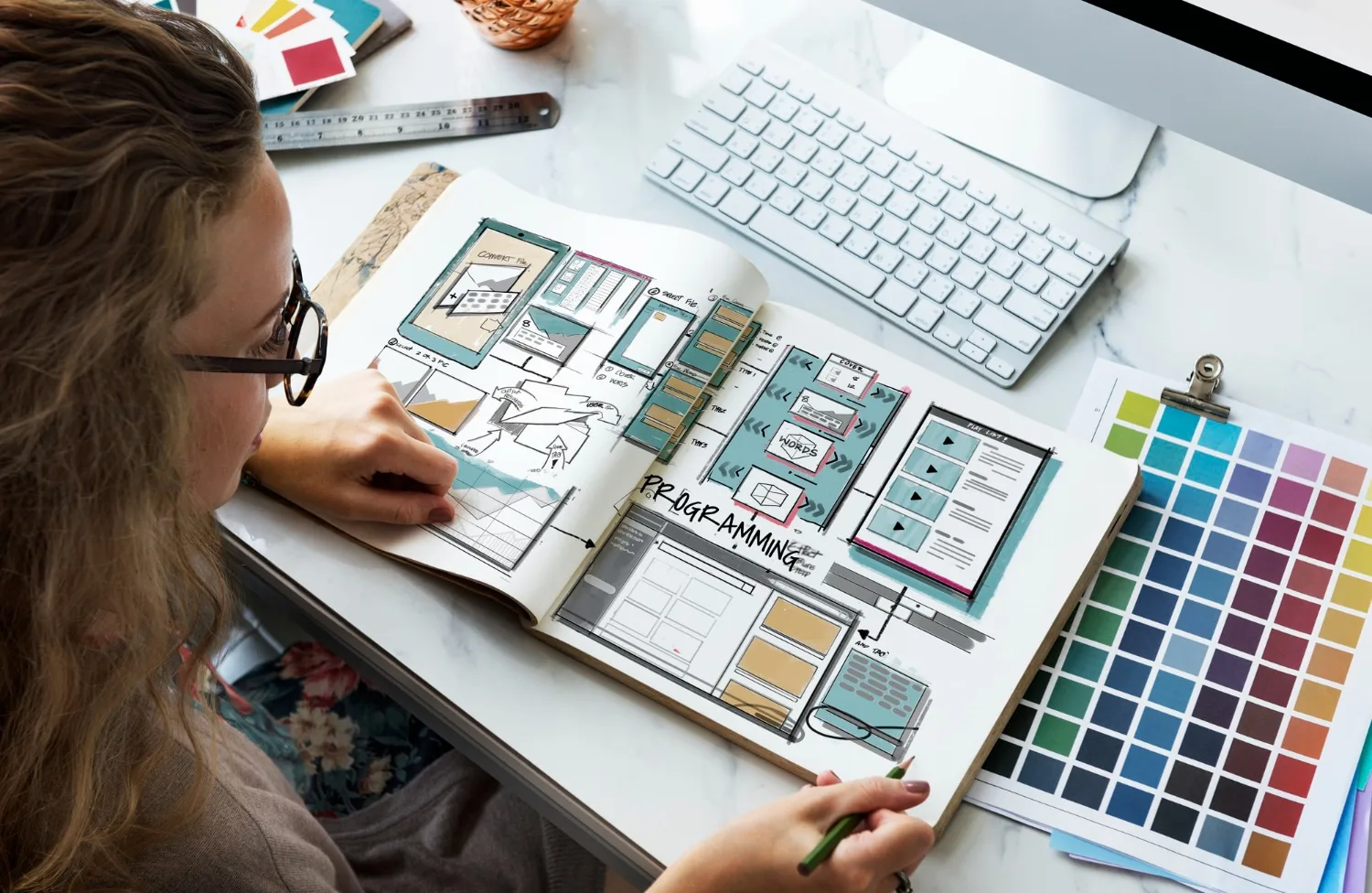 Un entrepreneur indépendant travaille sur l’ordinateur avec une maquette de landing page et un tableau de bord de conversion affichés à l’écran.