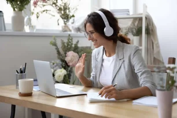 Formateur échangeant avec un apprenant devant un écran affichant un parcours de formation personnalisé