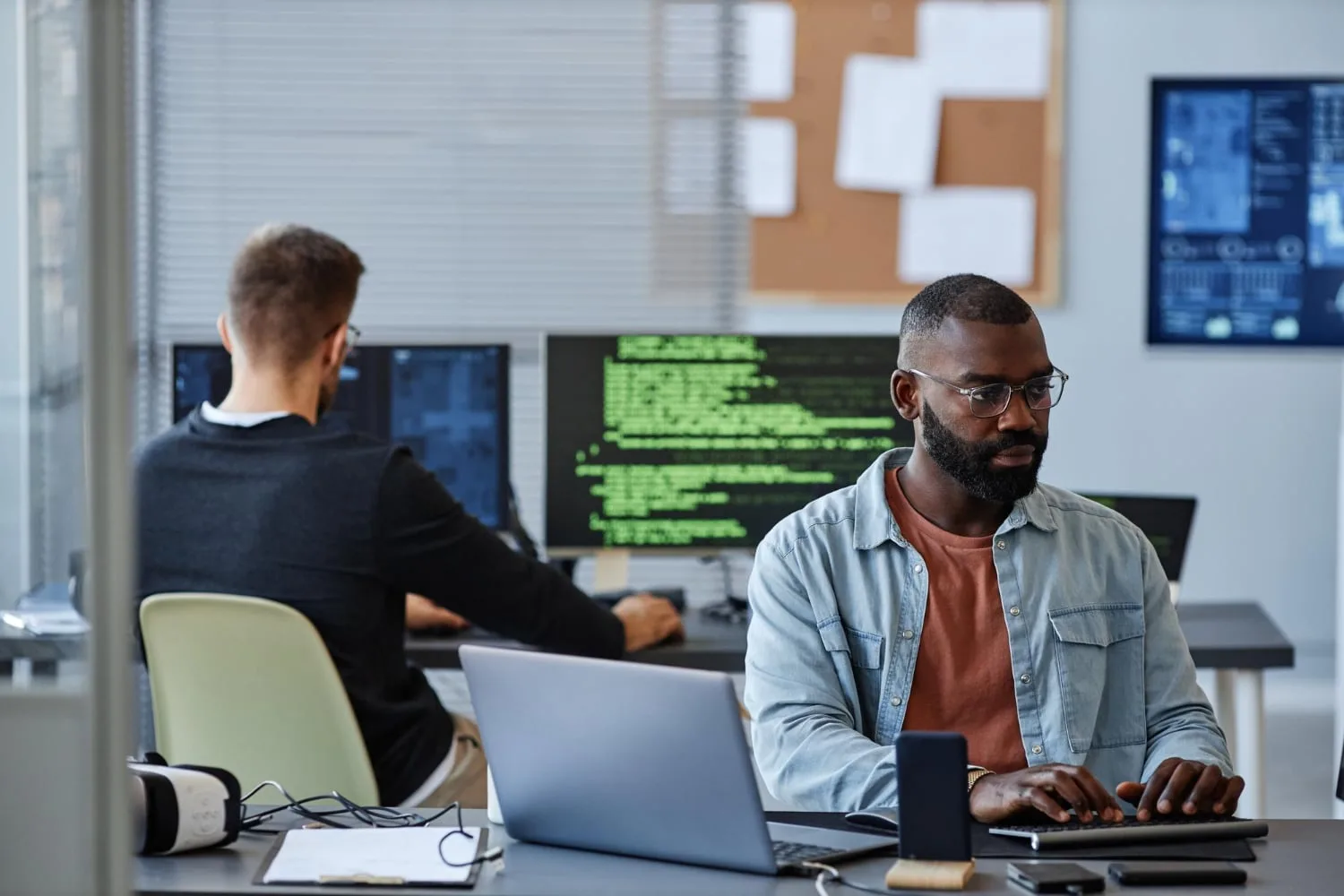 Professionnel de la cybersécurité devant plusieurs écrans affichant des alertes et des tableaux de supervision réseau