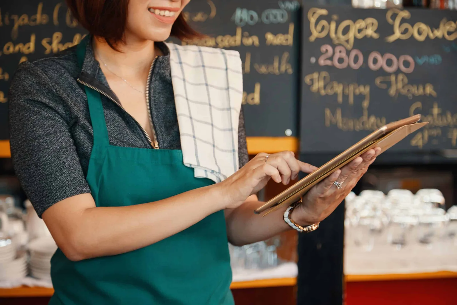 Commerçant encaissant un client sur une tablette reliée à une imprimante ticket et à un tiroir-caisse dans une boutique
