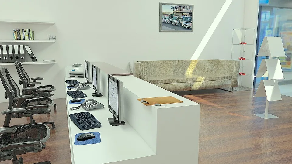 Un entrepreneur compare des offres de domiciliation sur ordinateur avec des documents administratifs et une adresse professionnelle visible sur l’écran.