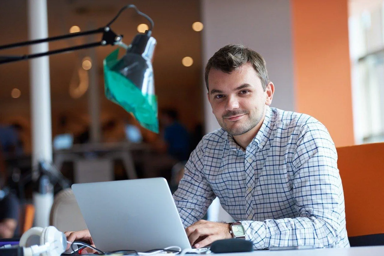 Micro-entrepreneur consultant un avis de situation Sirene sur ordinateur avec des documents administratifs à côté