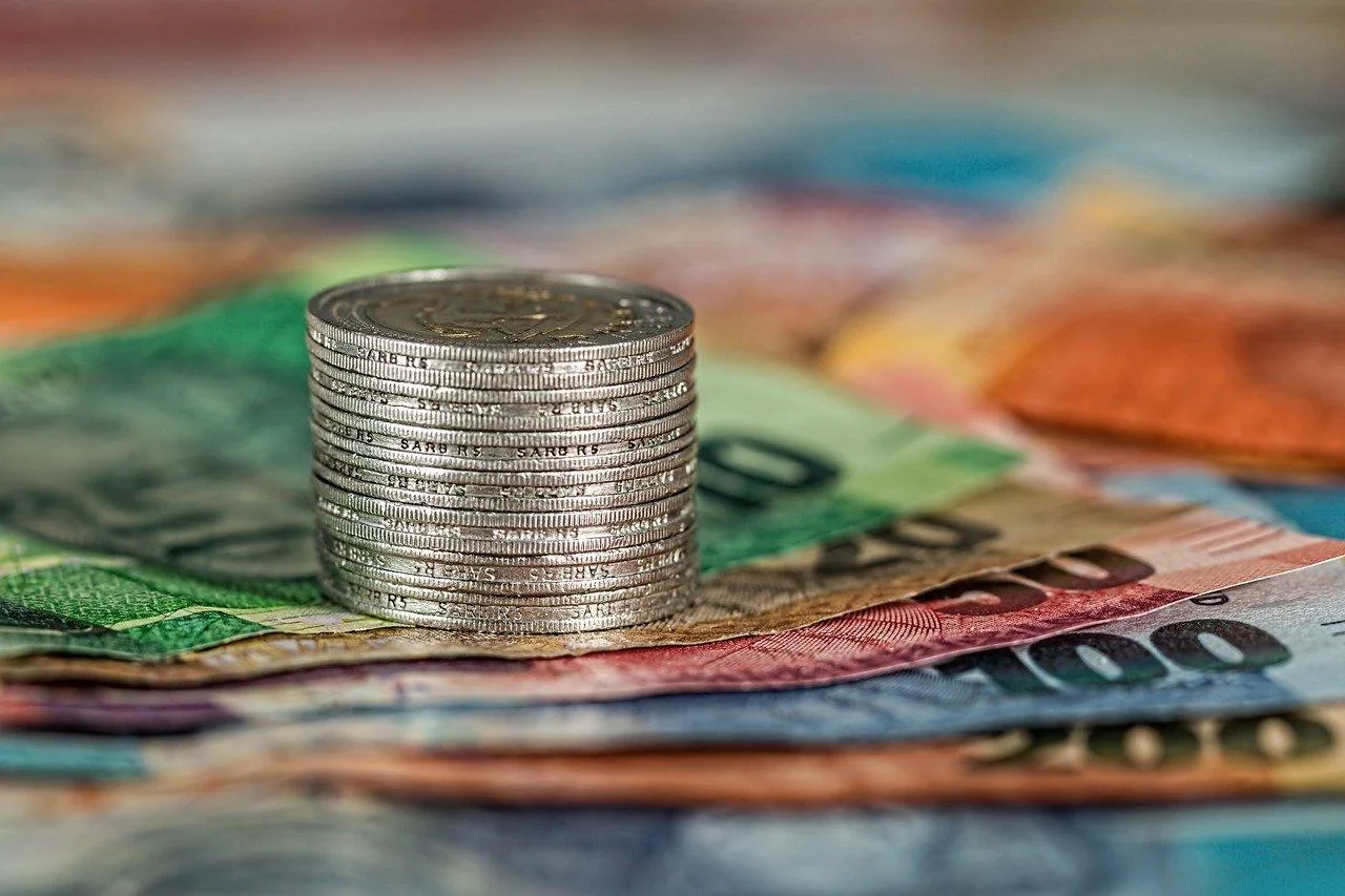 Un entrepreneur individuel consulte sa déclaration de revenus sur un ordinateur, avec des factures et un classeur de comptabilité à côté.
