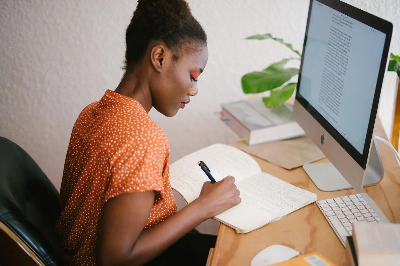 Un entrepreneur individuel remplit sa déclaration de revenus sur un ordinateur portable, avec des documents comptables à côté
