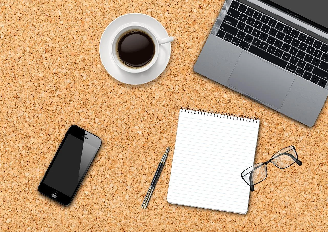 Entrepreneur solo analysant un tableau de prévisionnel sur ordinateur portable avec calculatrice et carnet sur une table