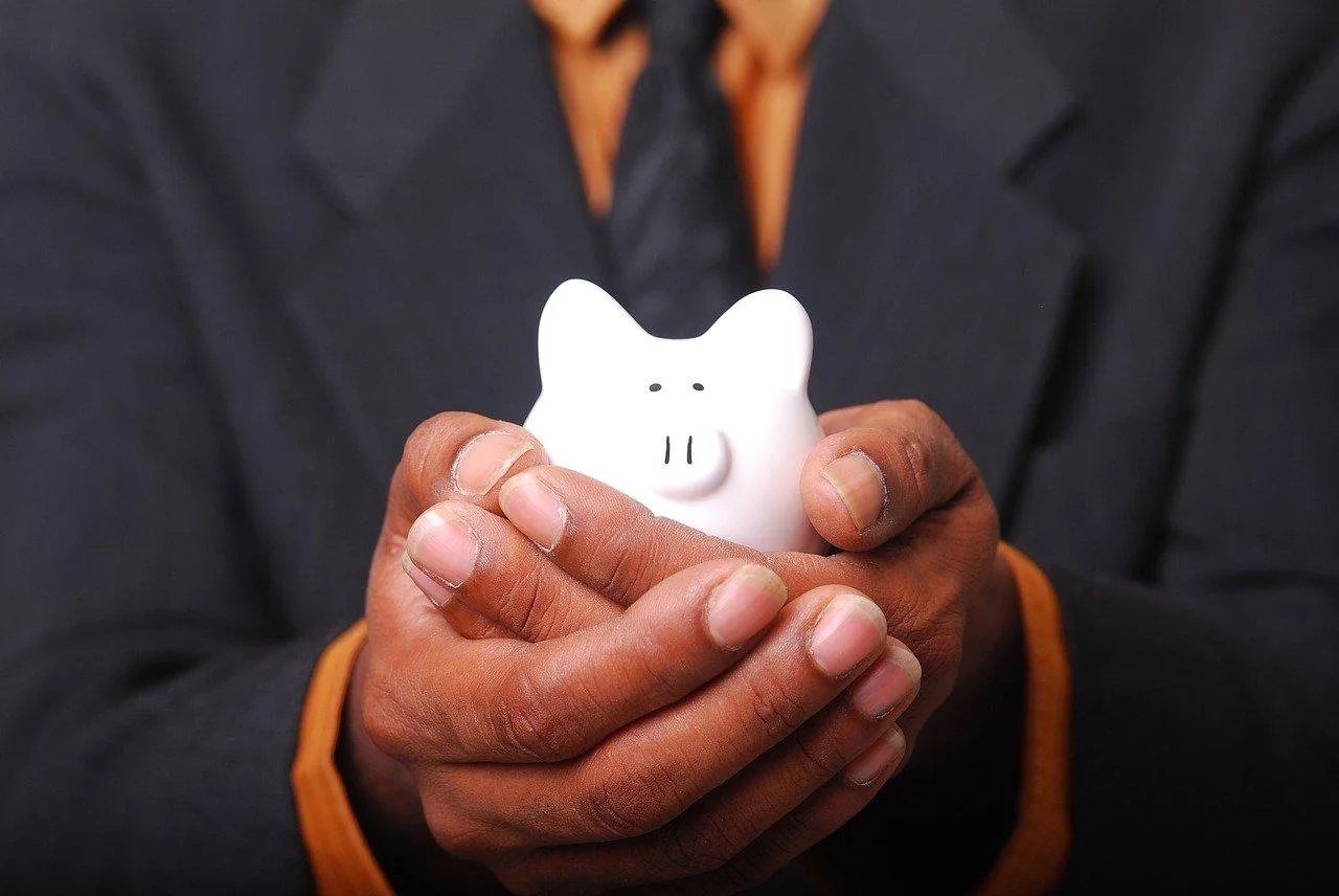 Entrepreneur individuel consultant ses relevés bancaires sur ordinateur avec une carte bancaire et des factures à côté