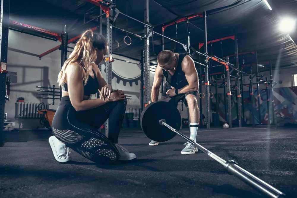Intérieur lumineux d’une salle de sport avec machines de musculation, tapis de course et comptoir d’accueil