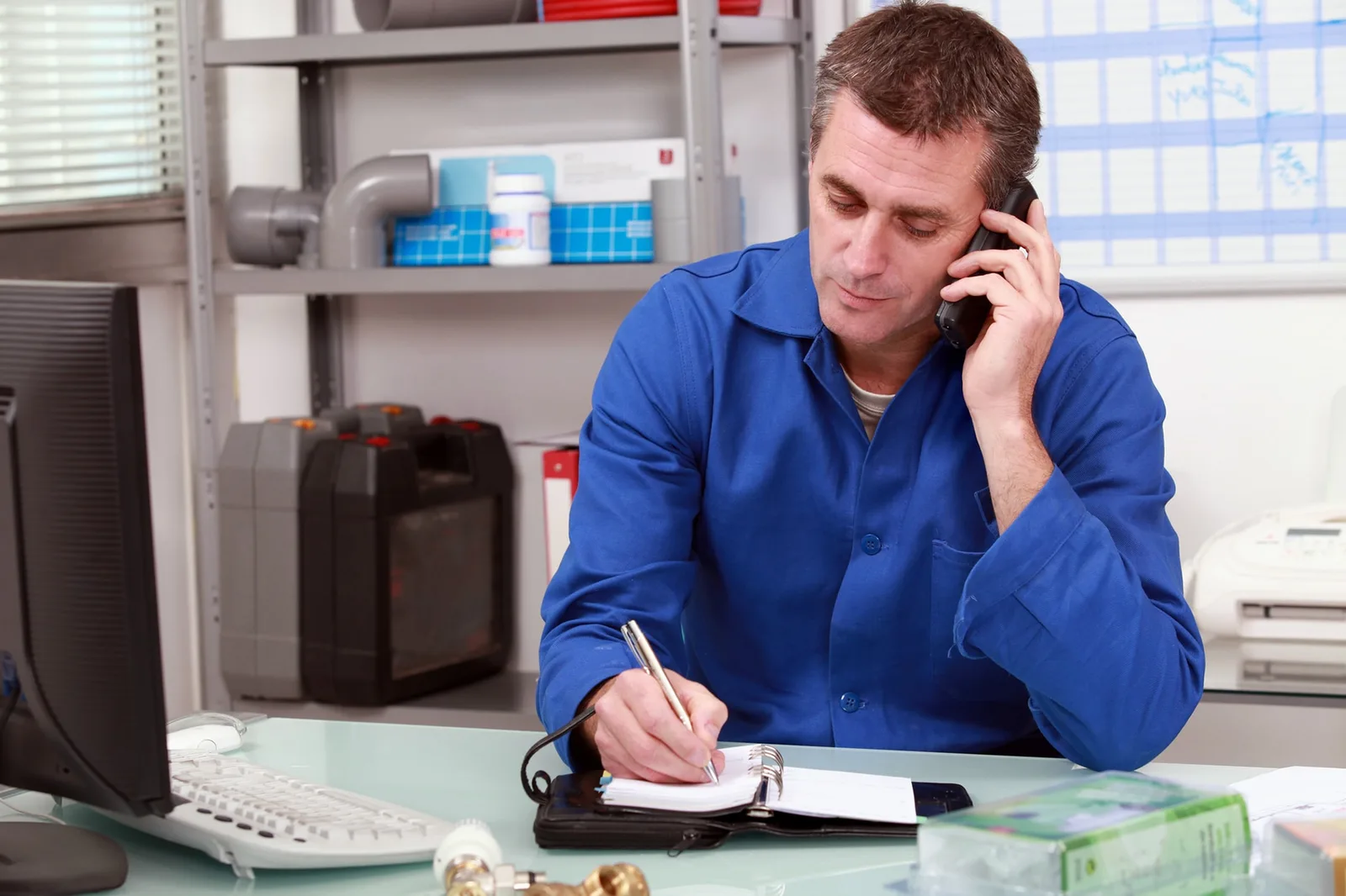 Un entrepreneur individuel consulte ses cotisations sociales sur un ordinateur portable, avec des documents administratifs sur son bureau.