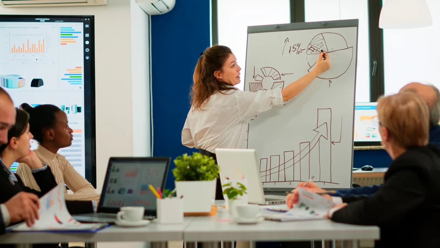 Entrepreneur individuel consultant un dossier de financement avec calculatrice, relevés bancaires et ordinateur portable sur un bureau