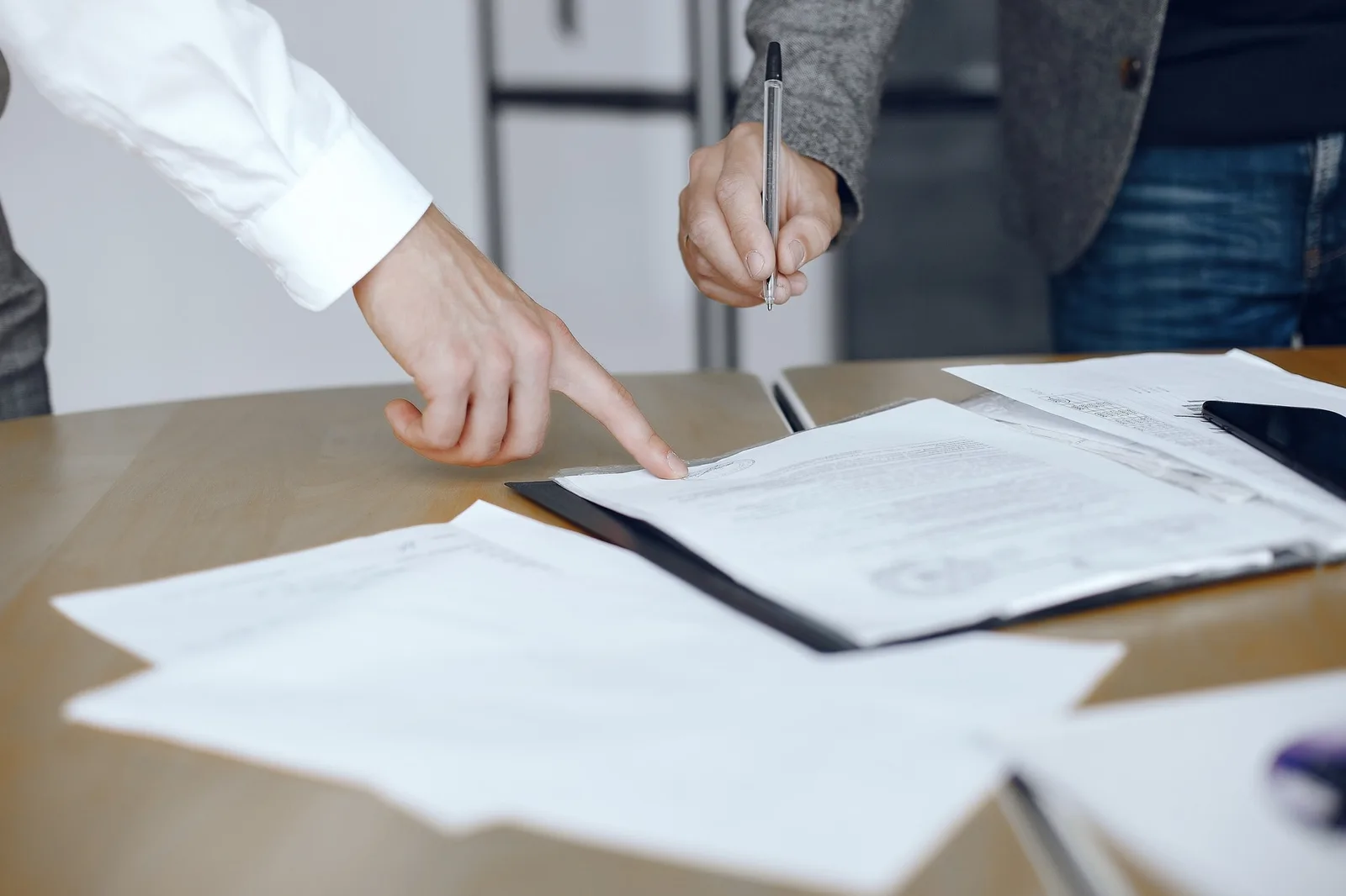 Une dirigeante d’entreprise consulte un extrait Kbis sur son ordinateur, avec un dossier d’immatriculation à côté
