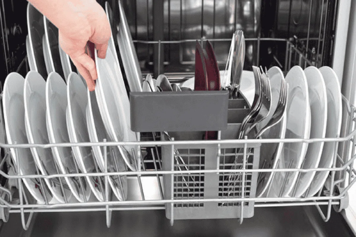 Deux machines professionnelles en inox dans une cuisine de restaurant : un lave-verre compact et un lave-vaisselle à capot.