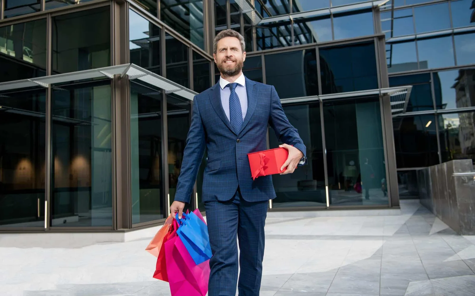 Une entrepreneure remet un coffret cadeau sobre et personnalisé à un client dans un bureau lumineux.