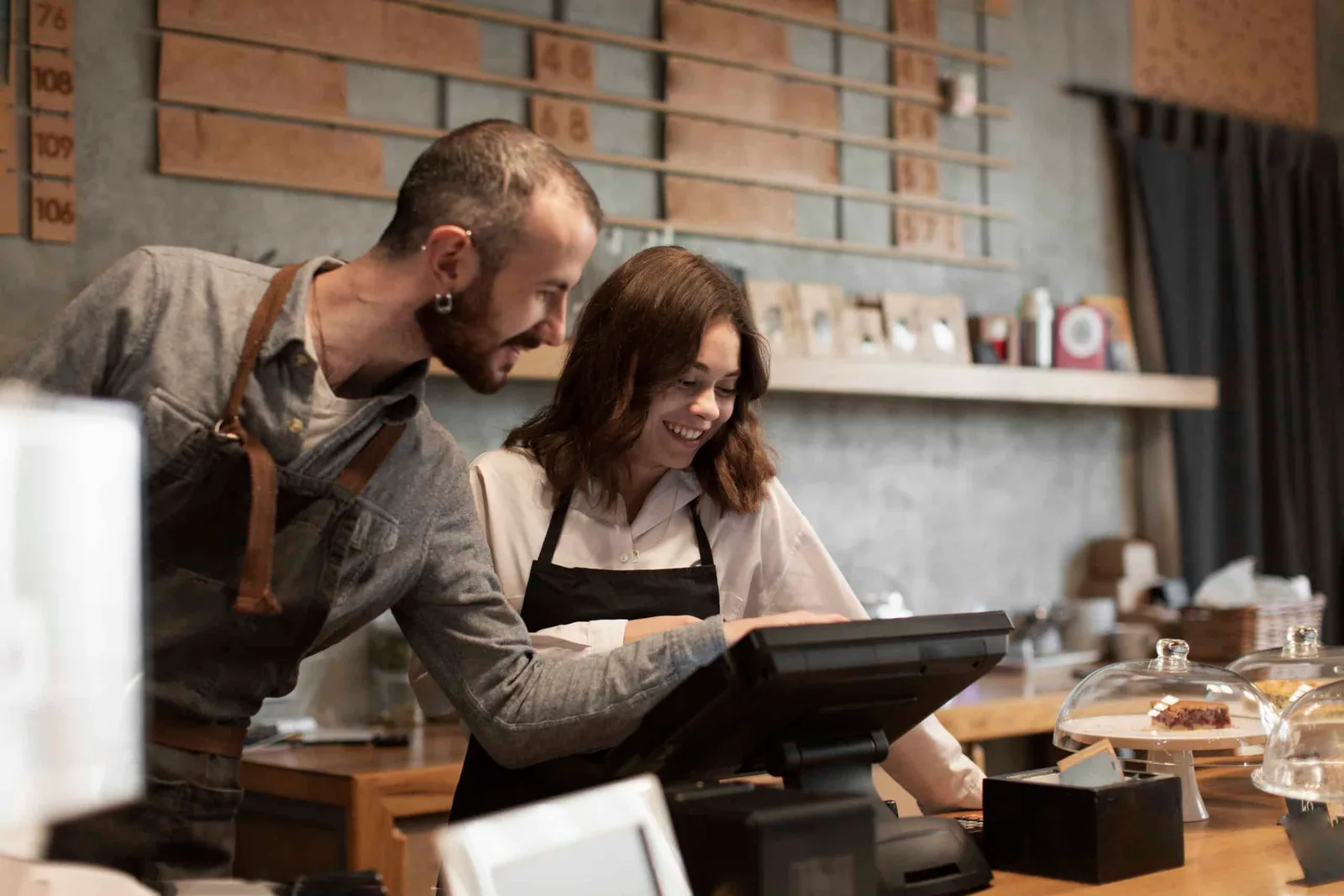 Propriétaire et locataire-gérant se serrant la main devant un commerce avec enseigne, documents de contrat sur une table