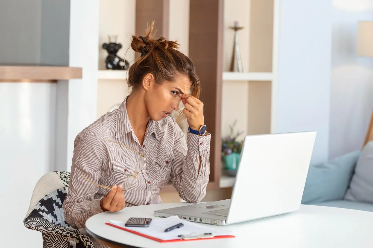 Entrepreneur seul en train d’analyser ses comptes et son plan d’action devant un ordinateur dans un bureau sobre