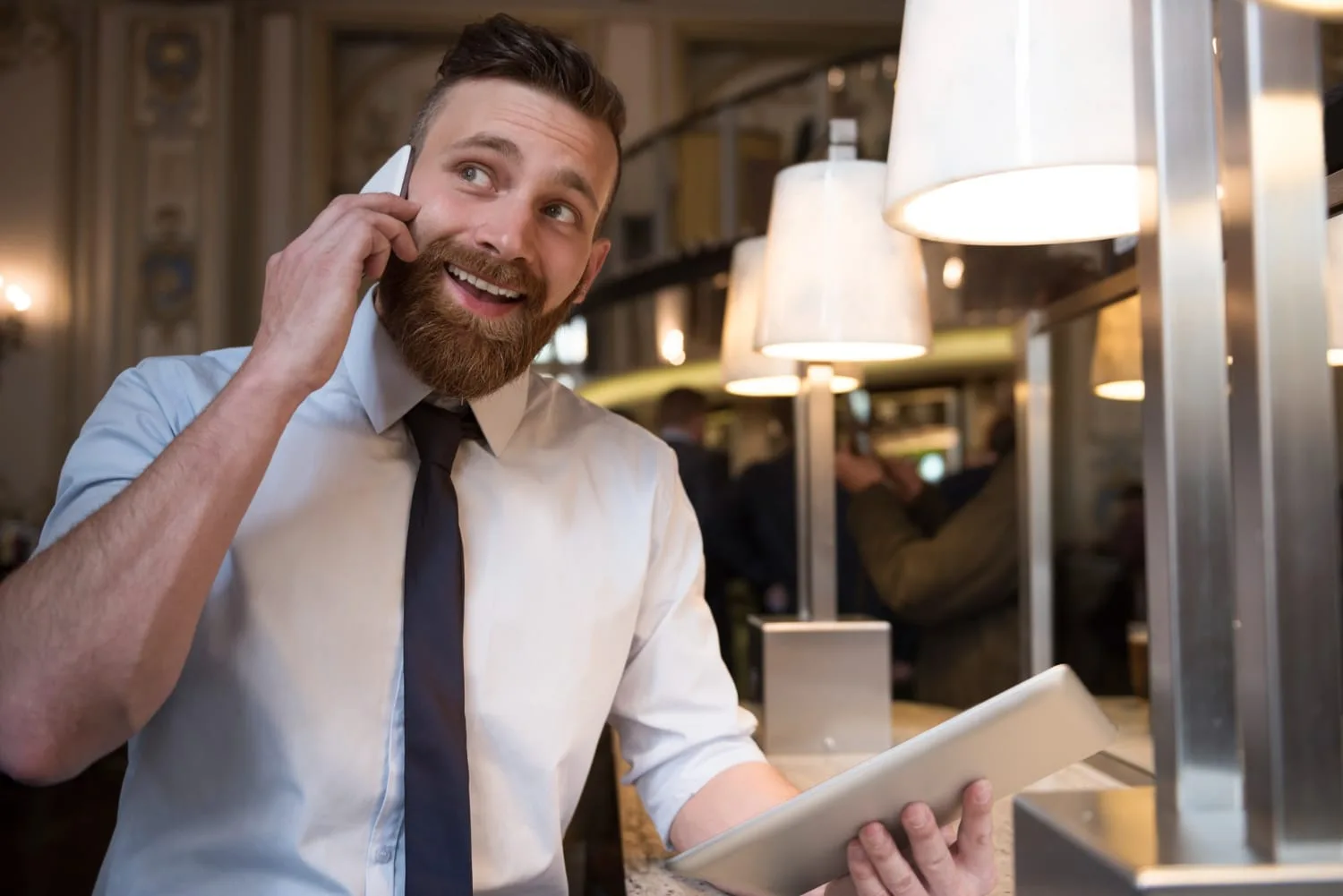 Entrepreneur indépendant échangeant avec un premier client autour d’un ordinateur portable dans un espace de travail